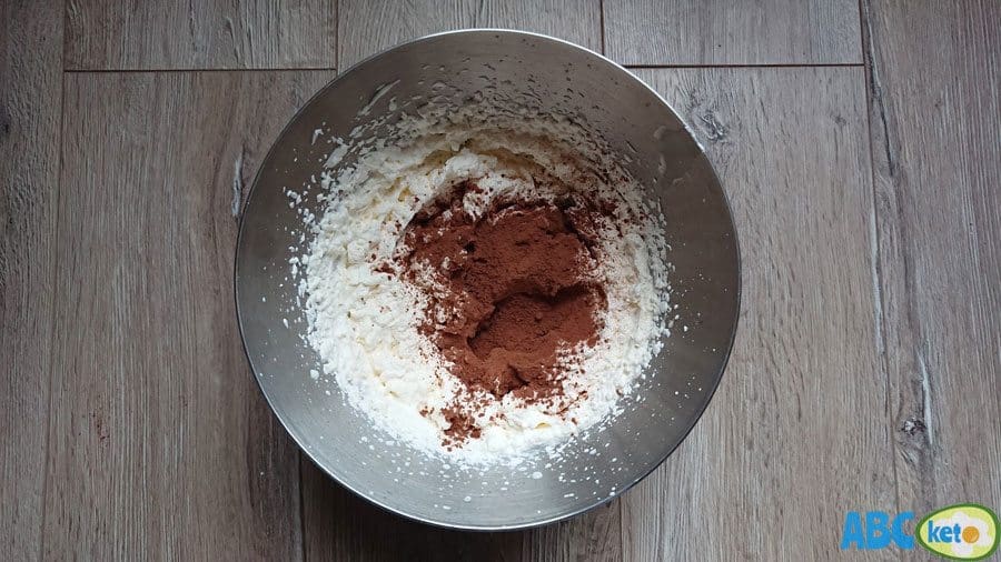 Keto chocolate mousse instructions: adding cocoa powder and stevia to whipped cream